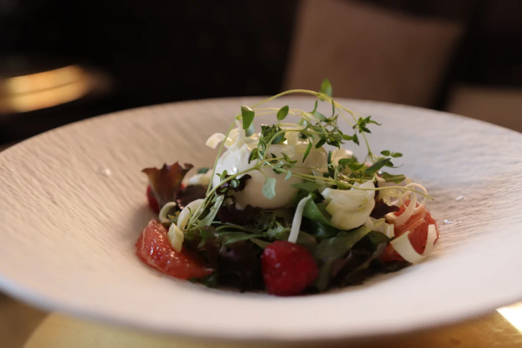 Färsk burrata med citrus, bär, ruccola och örter som antipasti på Ciao Ciao IV i Vasastan
